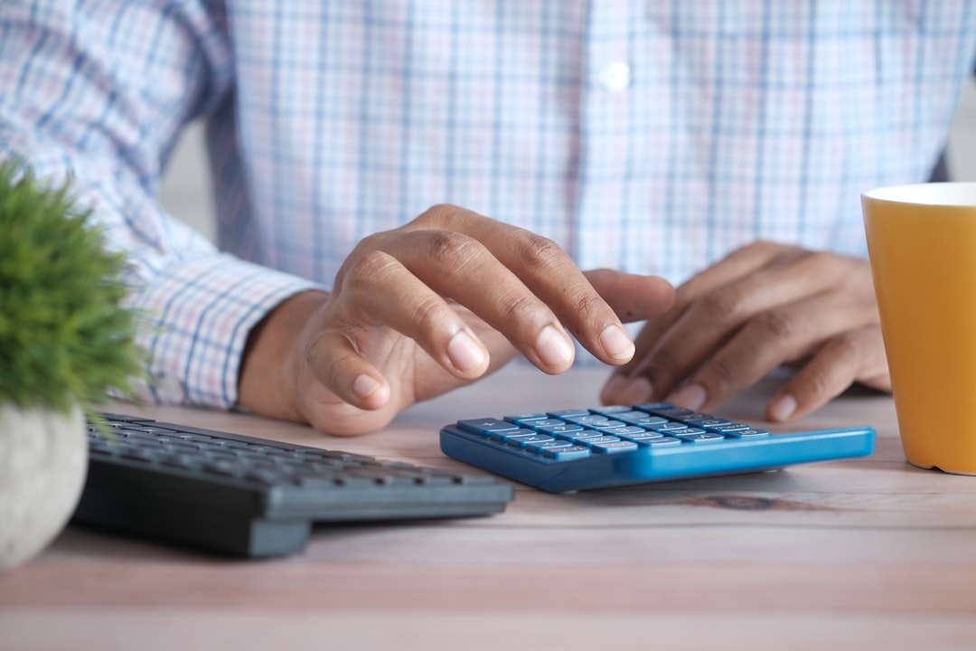 accountant calculating GST return filing charges using a calculator