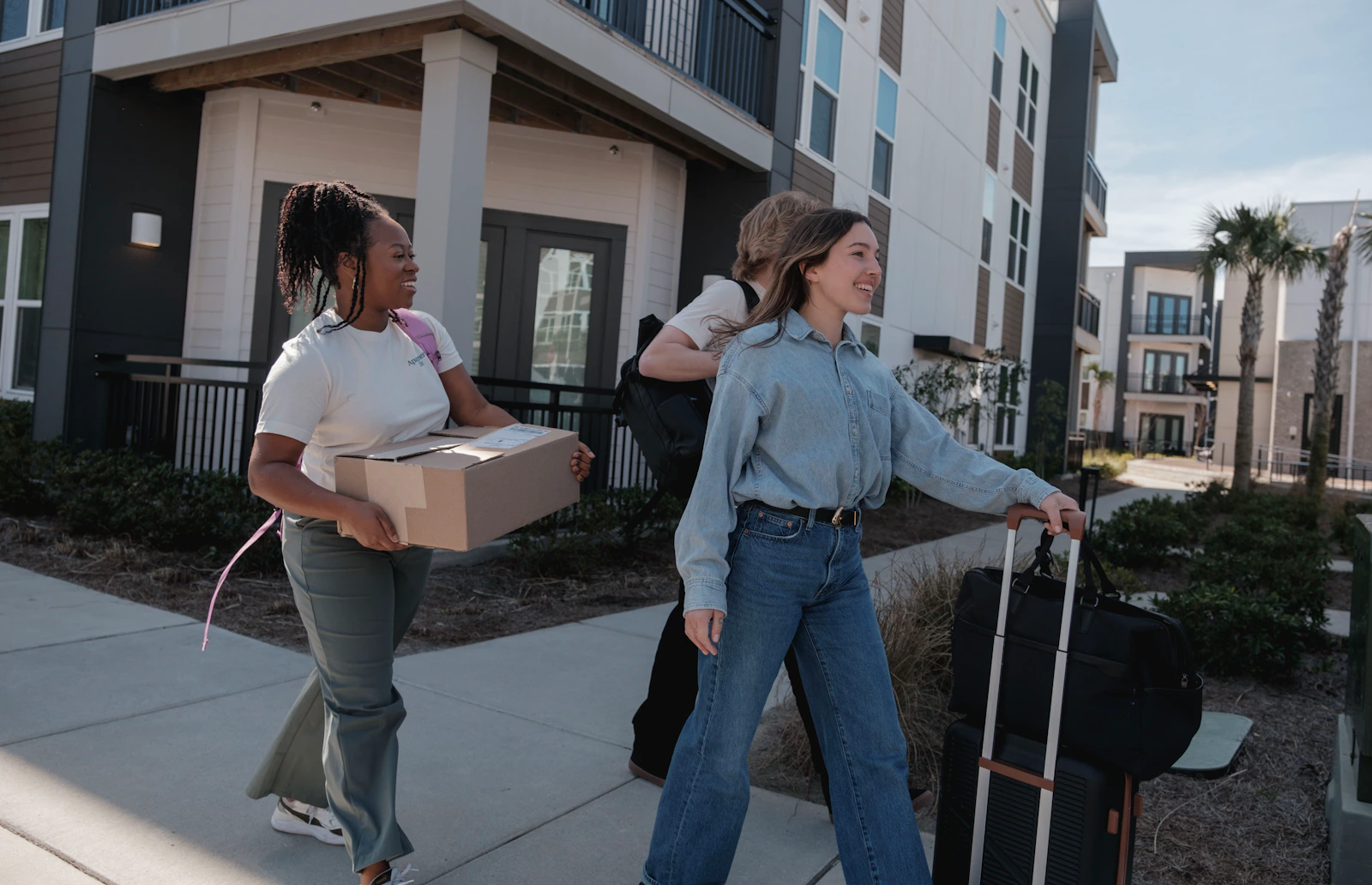House shifting charges in Bangalore for 2BHK with movers carrying boxes outside an apartment building