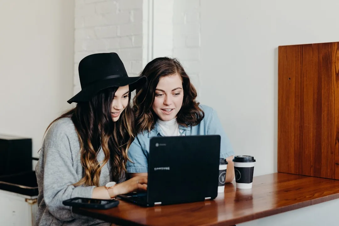 Two people reviewing website options on a laptop