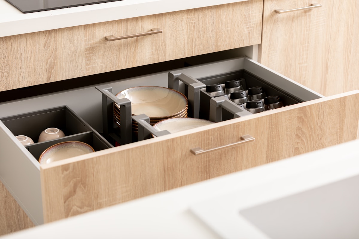 Close-up of soft-close kitchen cabinet drawer hardware and metal channel